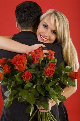 Žena s kytici růží objímající muže
