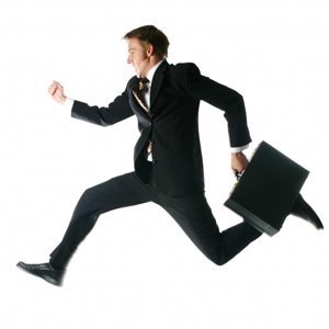 Snímek běžícího muže v obleku s kufříkem v ruce