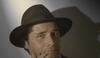 Fotografie zachycující muže s kloboukem na hlavě