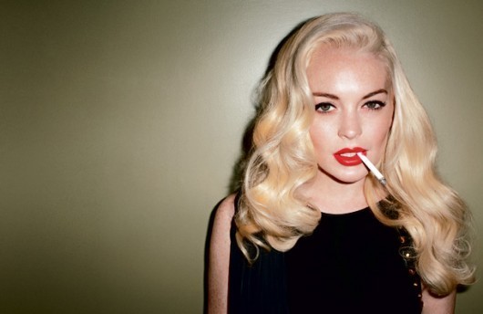 Fotografie ženy s blond vlasy s cigaretou v puse
