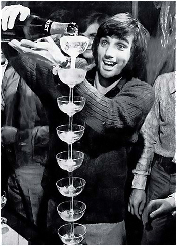 George Best při nalévání šampaňského do skleniček.