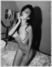 Černobílá fotografie klečící nahé ženy