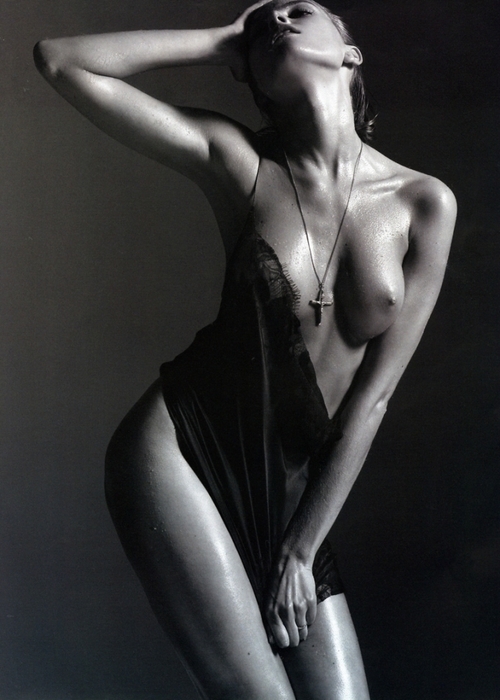 Černobílá fotografie ženy pózující v košilce s odhalenými prsy