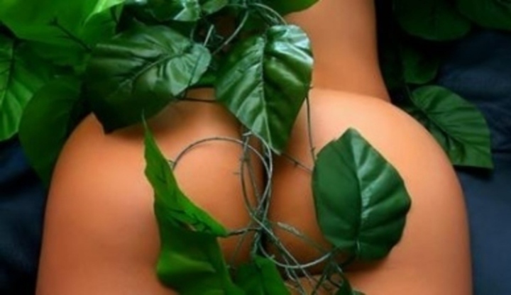 Snímek zachycující ženský zadek, který je krytý listím