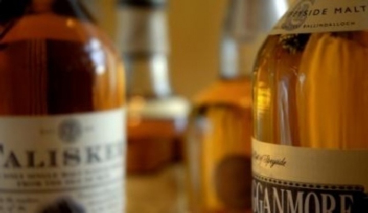 Snímek zachycující stojící láhve alkoholu typu Whiskey