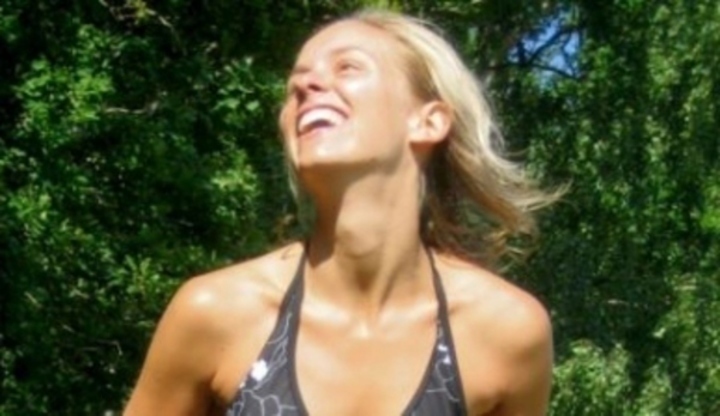 Snímek zachycující smějící se ženu, užívající si krásného počasí