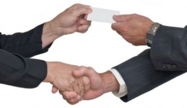 Snímek zachycující předávání vizitky a vzájemné podpory podáním ruky
