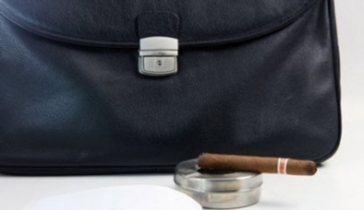 Fotografie zobrazující pánskou tašku s popelníkem a doutníkem