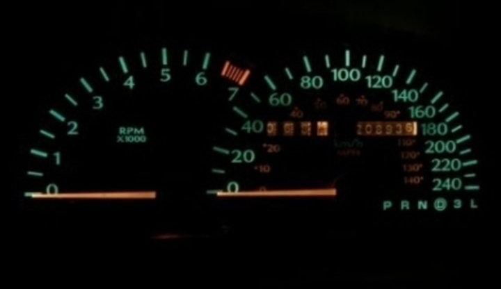 Fotografie zobrazující tachometr v autě v noci