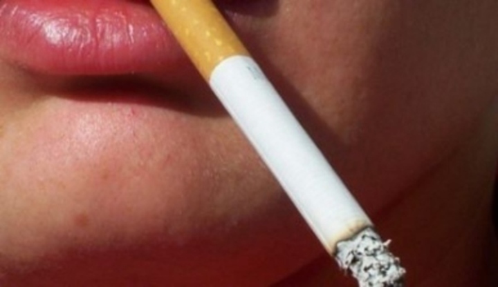 Fotografie zobrazující hořící cigaretu v ústech