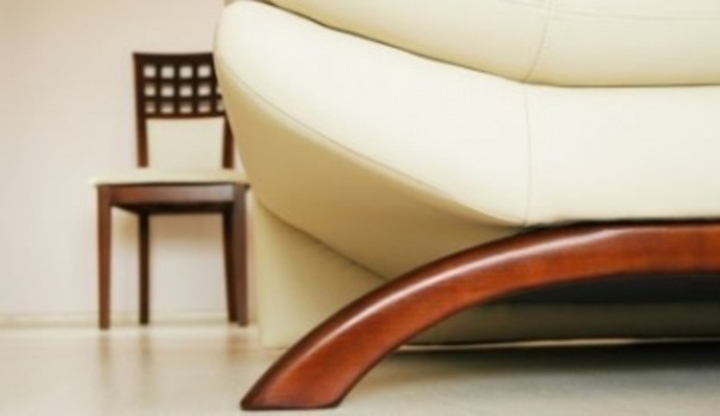 Fotografie s bílou pohovkou a dřevěnou židlí