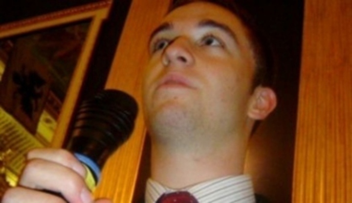 Fotografie zobrazující muže při mluvení do mikrofonu