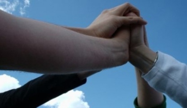 Fotografie čtyř ruk, které se společně drží