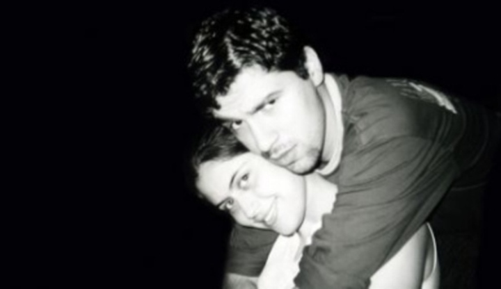 Černobílá fotografie, kdy muž objímá zezadu svou partnerku