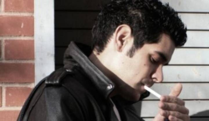 Fotografie muže, který si zapaluje cigaretu