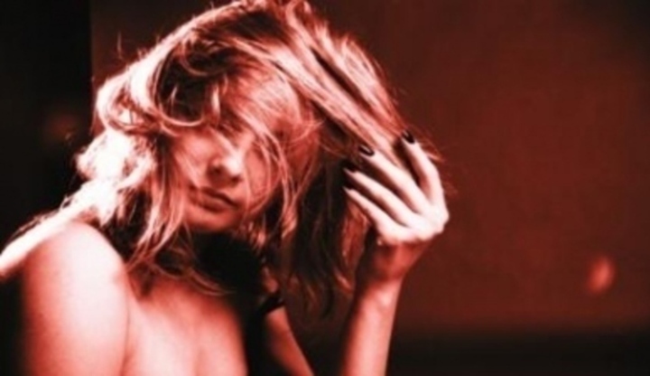 Fotografie zobrazující ženu při hře s vlasy