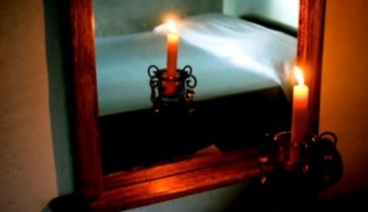 Fotografie svíčky hořící před zrcadlem
