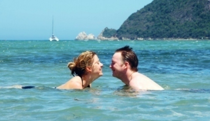 Fotografie mileneckého páru, který si užívá plavání v moři