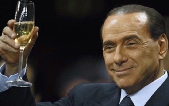 Italský bývalý premiér vlády Silvio Berlusconi při pozvednutí sklenice se šampaňským
