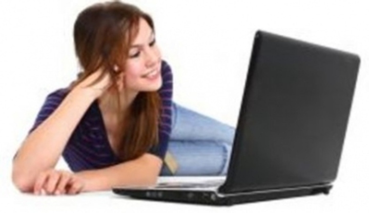 Snímek zachycující ženu ležící u notebooku