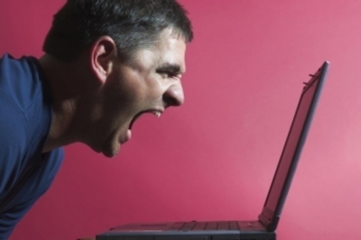 Fotografie muže křičícího na monitor od notebooku