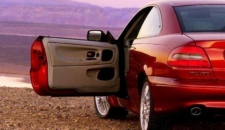 Fotografie červeného osobního automobilu s otevřenými dveřmi od řidiče