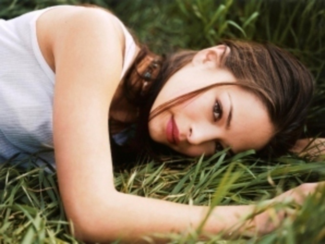 Americká herečka Kirsten Kreuk při focení v trávě