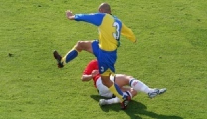 Fotografie zachycující dva hráče fotbalu při tzv. "skluzu"