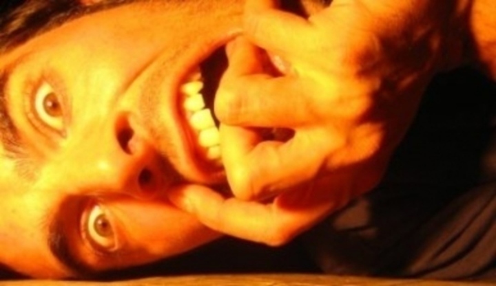 Fotografie znázorňující muže, který si kouše ruku