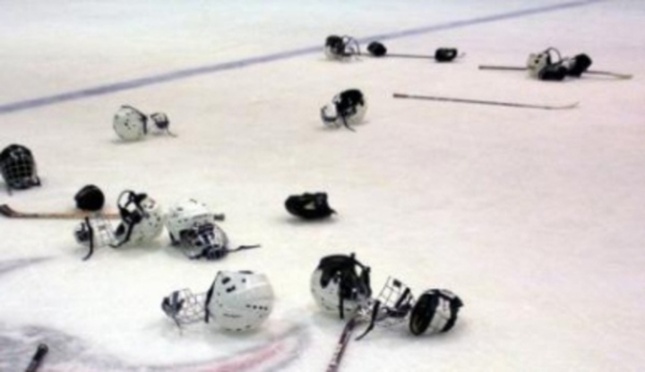 Pohled na ledovou plochu s pohozenými helmami na lední hokej