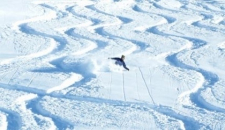 Fotografie lyžaře sjíždějící svah