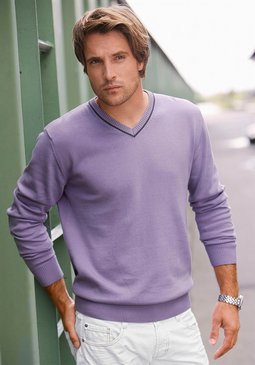 Muž ve fialovém svetru a bílých kalhotech