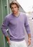 Muž ve fialovém svetru a bílých kalhotech