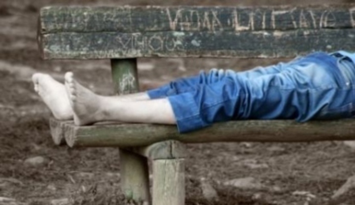 Fotografie zachycující lidské nohy v jeansech a ležící na lavičce