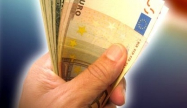 Fotografie ruky, která drží bankovky eura v ruce