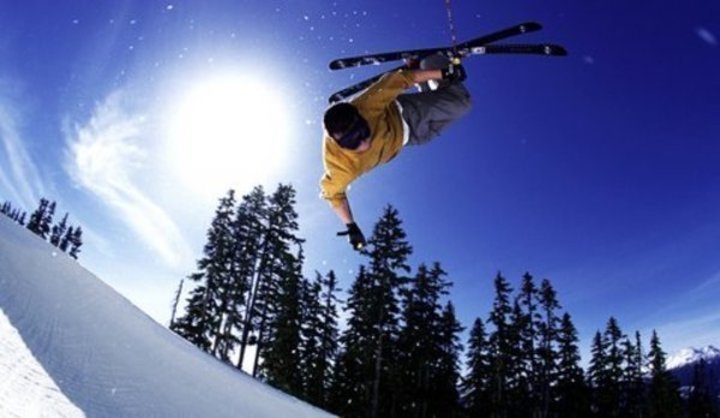 Fotografie zachycující lyžaře při saltu na svahu