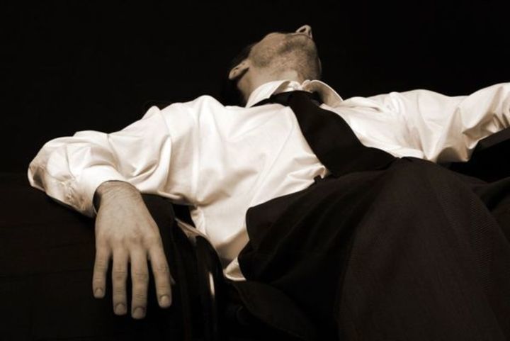Černobílá fotografie muže ležícího na pohovce