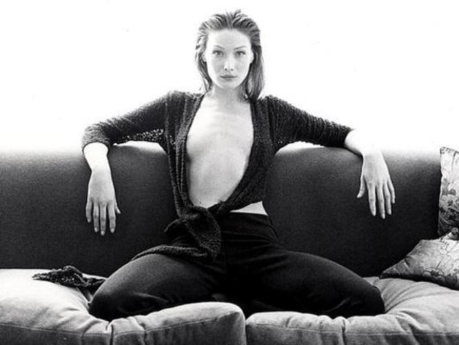 Černobílá fotografie ženy sedící na pohovce