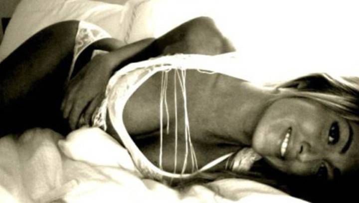 Černobílá fotografie ženy ležící v posteli