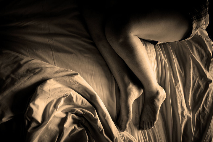 Ženské nohy na neustlané posteli