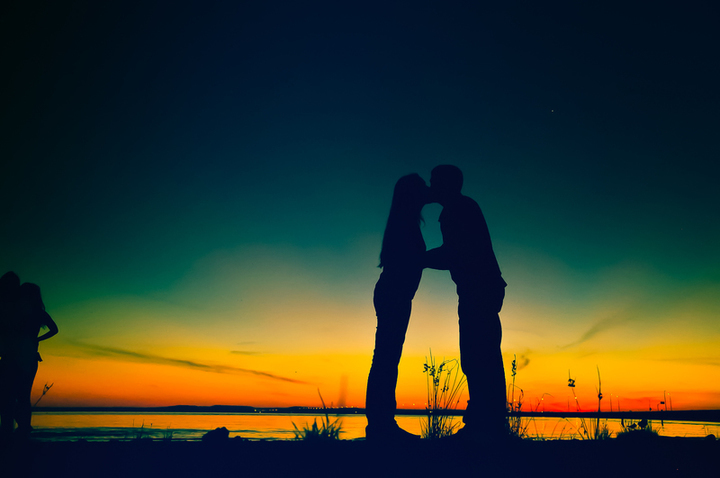 zamilovaný pár se líbá při západu slunce