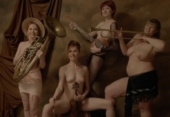 Fotografie čtyř polonahých žen s hudebními nástroji