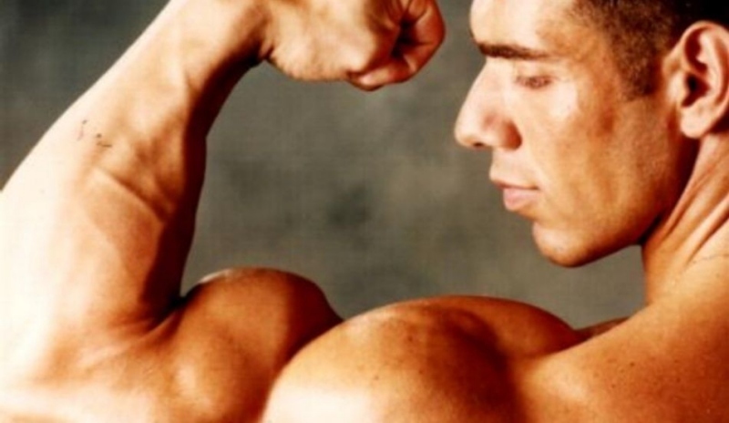 Fotografie muže pózujícího s bicepsem