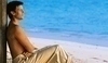 Muž sedící na pláži užívající si letní pohodu