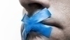 Fotografie muže, který má přelepeny ústa modrou páskou