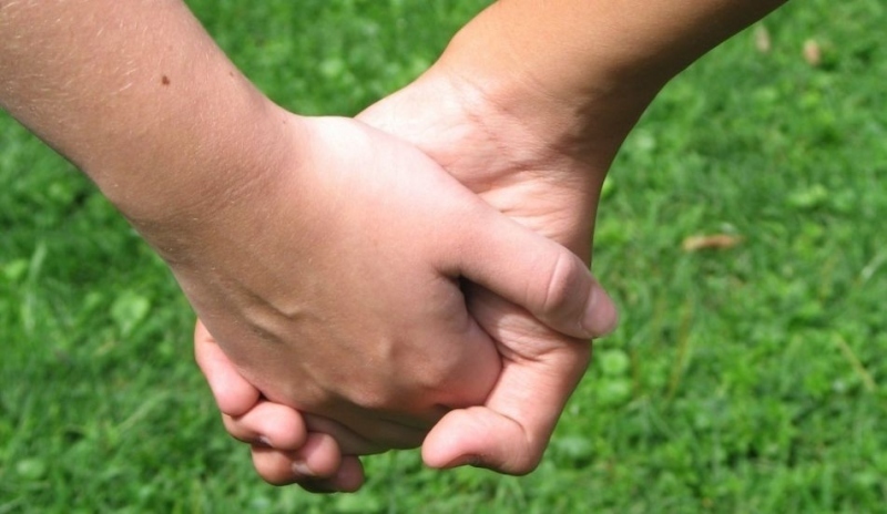 Fotografie dvou lidí jak se drží za ruce