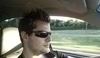 Fotografie muže ve slunečních brýlích jedoucí v autě