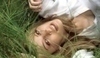 Fotografie blondýnky ležící v trávě