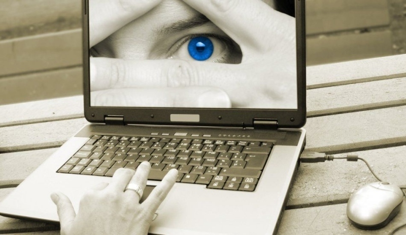 Obrázek otevřeného notebooku s modrým okem na monitoru