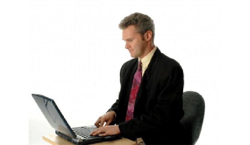 Muž v obleku sedící u počítače
